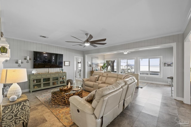 living room featuring a ceiling fan, visible vents, crown molding, and baseboards