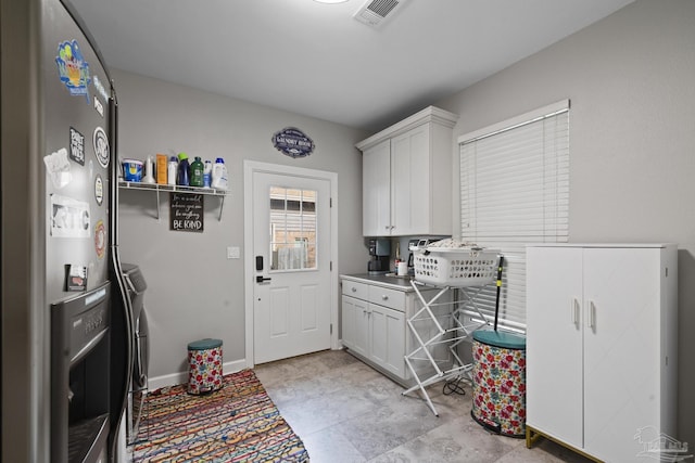 laundry room featuring baseboards, cabinet space, visible vents, and washer and dryer