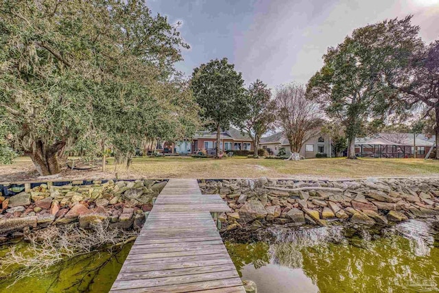 view of dock featuring a lawn