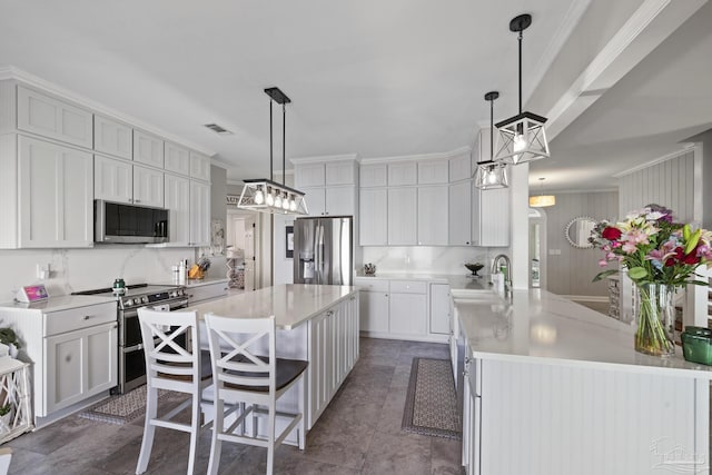 kitchen with visible vents, a kitchen island, stainless steel appliances, light countertops, and backsplash