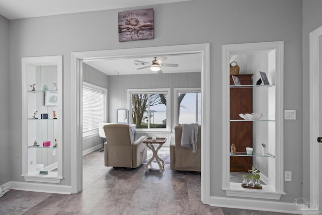 sitting room featuring ceiling fan and baseboards