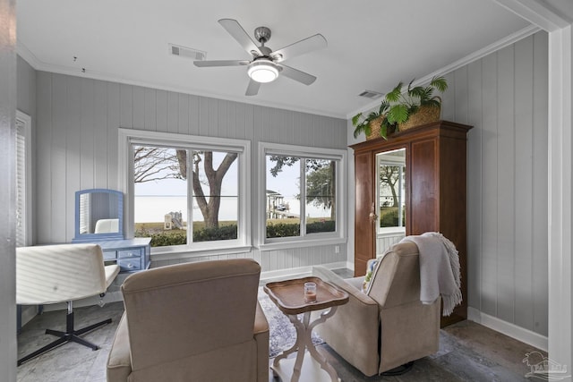 sitting room featuring ceiling fan, ornamental molding, visible vents, and baseboards