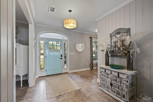 entrance foyer featuring ornamental molding, visible vents, and baseboards