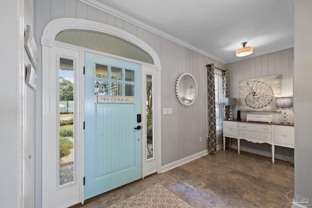 entrance foyer featuring ornamental molding and baseboards