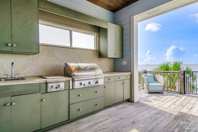 2961 Bay St, Gulf Breeze, FL 32563 - kitchen featuring green cabinetry, a sink, light wood-style floors, backsplash, and light countertops