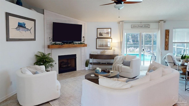 tiled living area featuring a fireplace and a ceiling fan