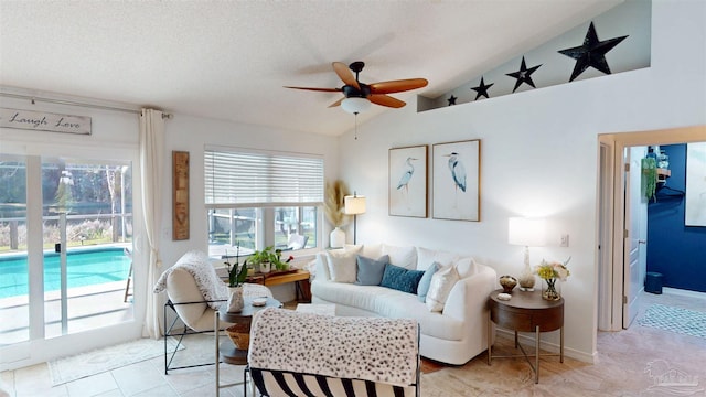 living area with a ceiling fan, vaulted ceiling, and a textured ceiling