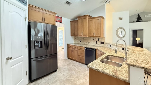 kitchen with lofted ceiling, a sink, visible vents, black dishwasher, and stainless steel fridge