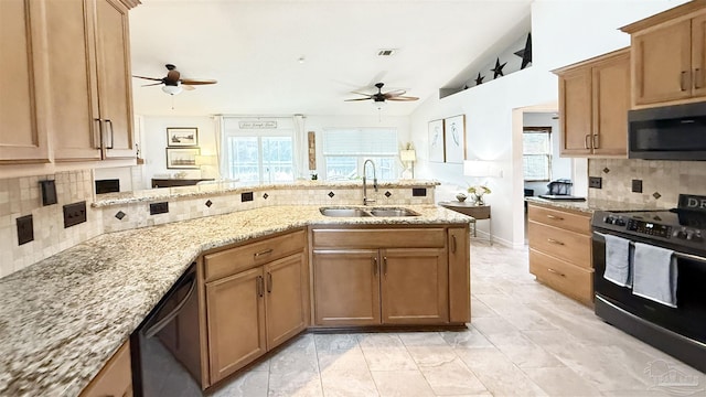 kitchen featuring light stone counters, a peninsula, a sink, vaulted ceiling, and black appliances