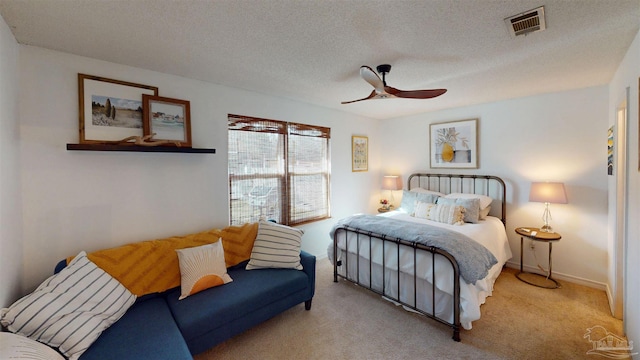 bedroom featuring carpet floors, visible vents, ceiling fan, a textured ceiling, and baseboards