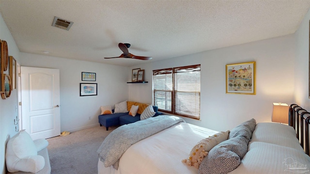 bedroom featuring carpet floors, visible vents, ceiling fan, a textured ceiling, and baseboards