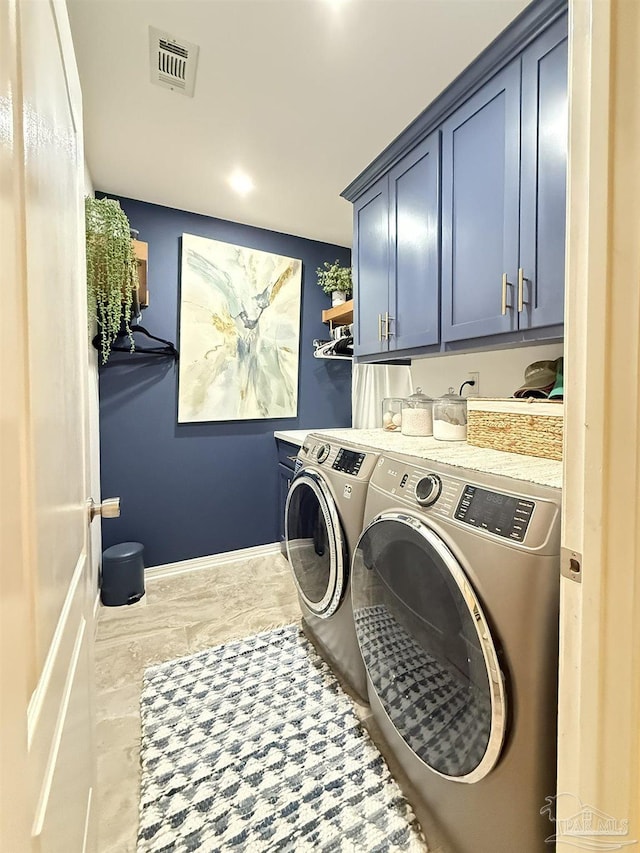 laundry area with visible vents, independent washer and dryer, cabinet space, and baseboards