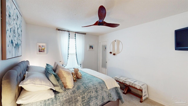 bedroom with ceiling fan, a textured ceiling, and light colored carpet