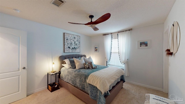 bedroom with a ceiling fan, visible vents, light carpet, and baseboards