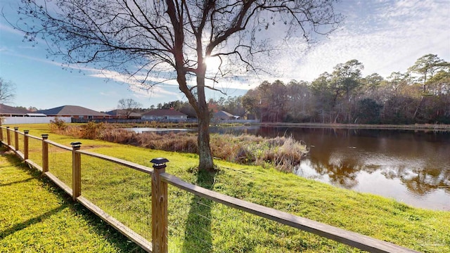 view of yard featuring a water view and fence