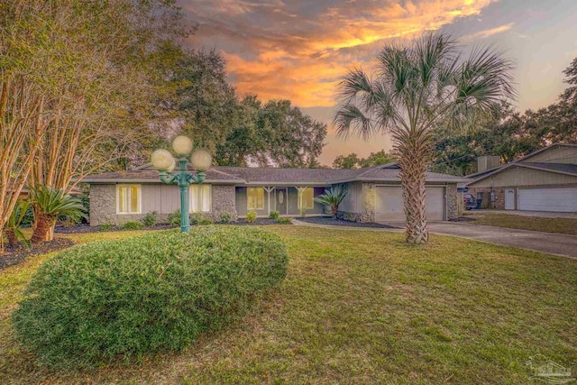 ranch-style home featuring a yard and a garage