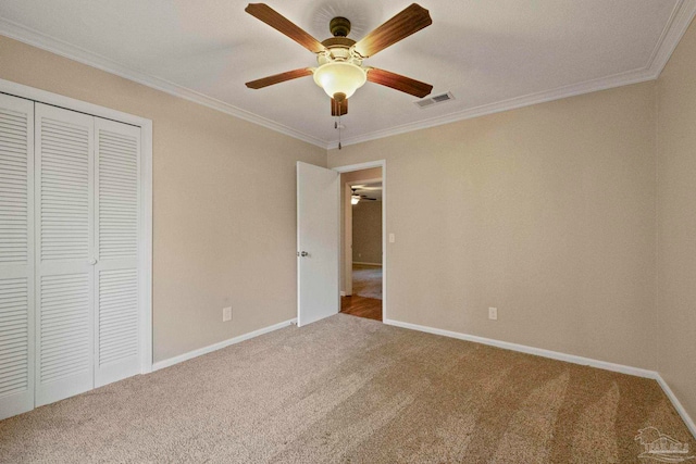 unfurnished bedroom featuring ornamental molding, carpet floors, and ceiling fan