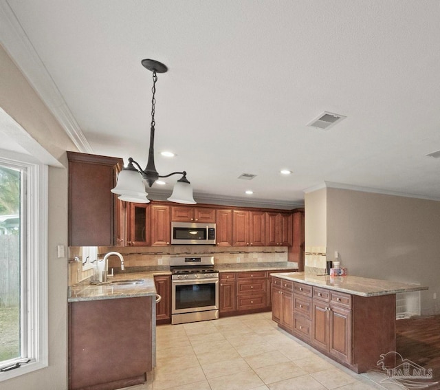 kitchen featuring ornamental molding, sink, decorative light fixtures, and stainless steel appliances