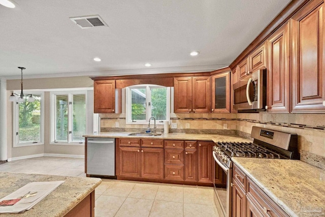 kitchen featuring appliances with stainless steel finishes, sink, backsplash, hanging light fixtures, and light tile patterned floors