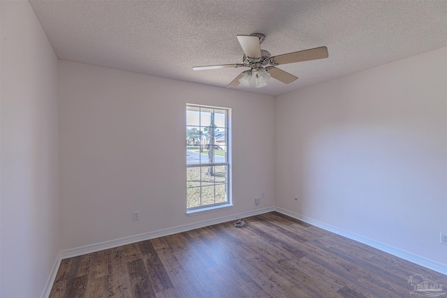 empty room featuring ceiling fan, a textured ceiling, baseboards, and wood finished floors