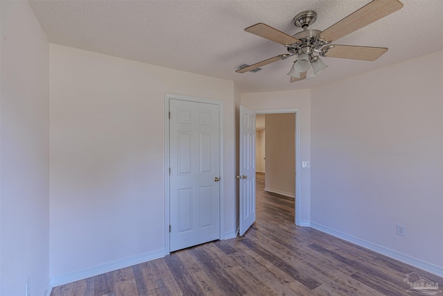 spare room with a ceiling fan, a textured ceiling, baseboards, and wood finished floors