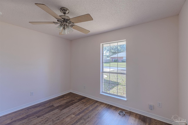 empty room with a textured ceiling, baseboards, and dark wood-style flooring