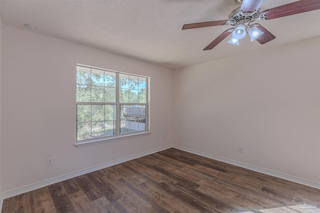 empty room with a textured ceiling, dark wood-type flooring, and baseboards