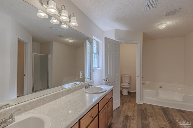 full bath featuring a stall shower, visible vents, a sink, and wood finished floors