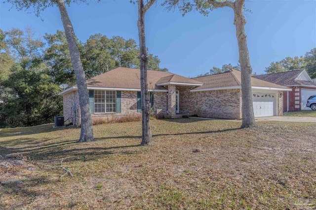 ranch-style house featuring brick siding, concrete driveway, a front yard, central AC, and a garage