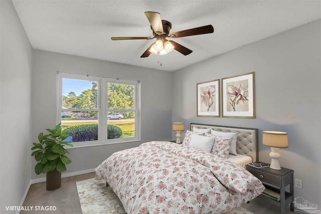 bedroom featuring ceiling fan, light colored carpet, and a textured ceiling