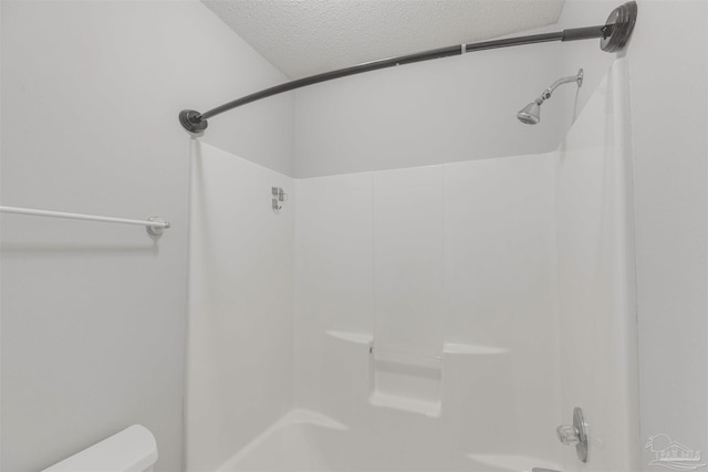 bathroom featuring a textured ceiling and toilet