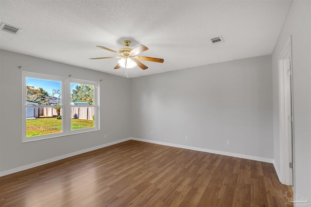 spare room featuring a textured ceiling, dark hardwood / wood-style floors, and ceiling fan