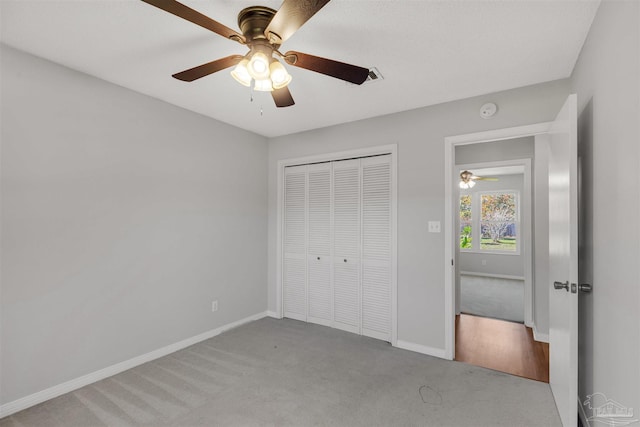 unfurnished bedroom with ceiling fan, a closet, and light colored carpet