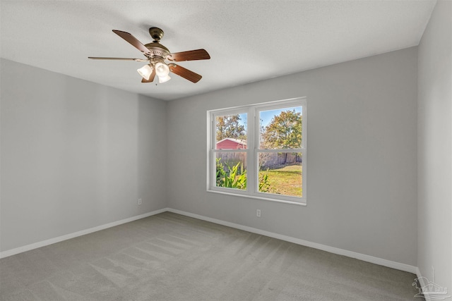 unfurnished room with light carpet, ceiling fan, and a textured ceiling