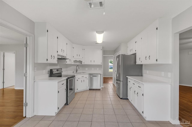 kitchen featuring appliances with stainless steel finishes, white cabinetry, and sink