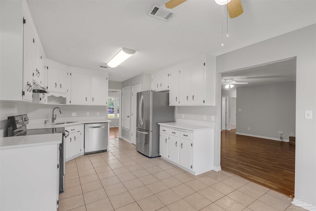 kitchen featuring stainless steel appliances, ceiling fan, sink, white cabinets, and light hardwood / wood-style floors