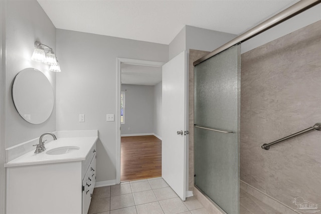 bathroom featuring wood-type flooring, vanity, and a shower with shower door