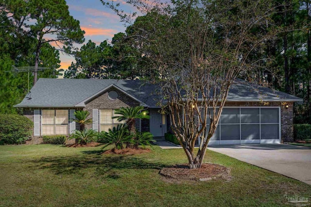 view of front of home with a garage and a lawn