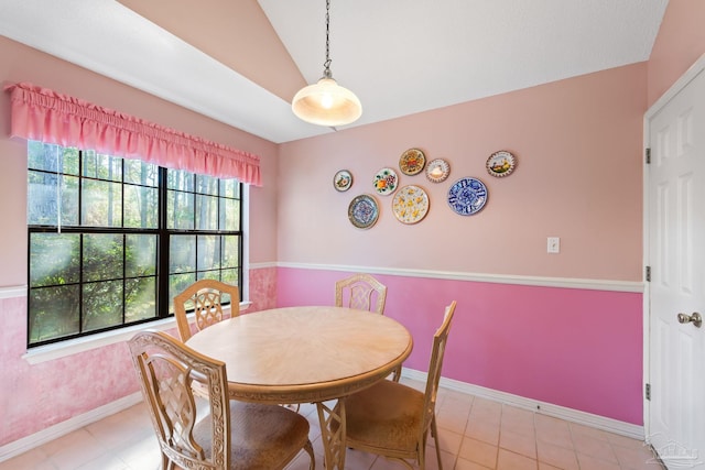 tiled dining area with lofted ceiling and plenty of natural light