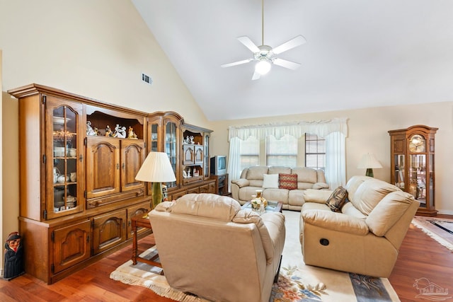 living room with dark wood-type flooring, ceiling fan, and high vaulted ceiling