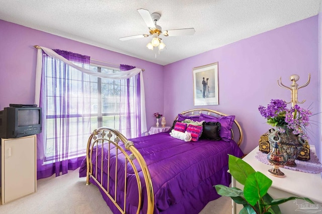 bedroom with ceiling fan, a textured ceiling, and carpet flooring