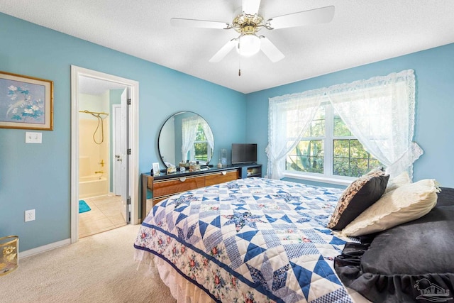 bedroom with ceiling fan, light colored carpet, a textured ceiling, and ensuite bathroom