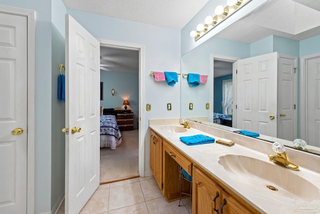 bathroom featuring ceiling fan, a textured ceiling, tile patterned floors, and vanity