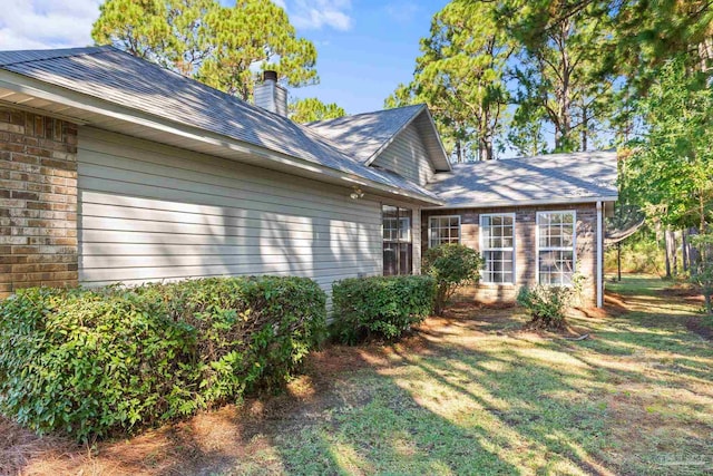 view of side of home with a yard