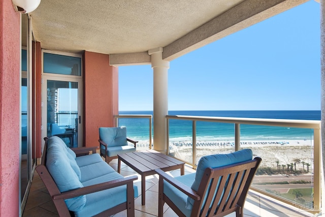 balcony featuring outdoor lounge area, a water view, and a beach view