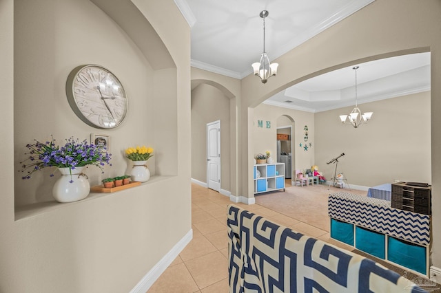 interior space featuring a chandelier, arched walkways, crown molding, light tile patterned floors, and baseboards