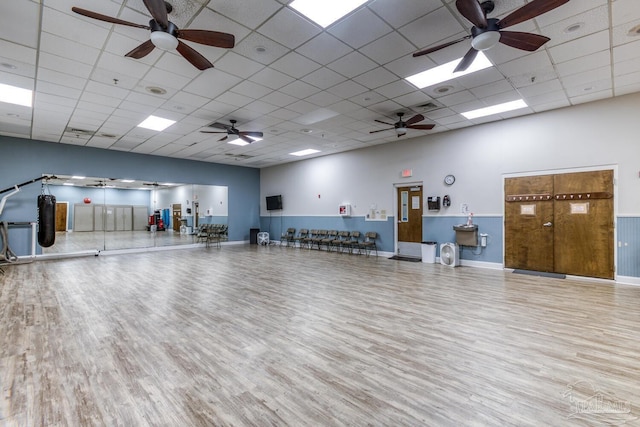 miscellaneous room featuring a ceiling fan, wood finished floors, a drop ceiling, and baseboards