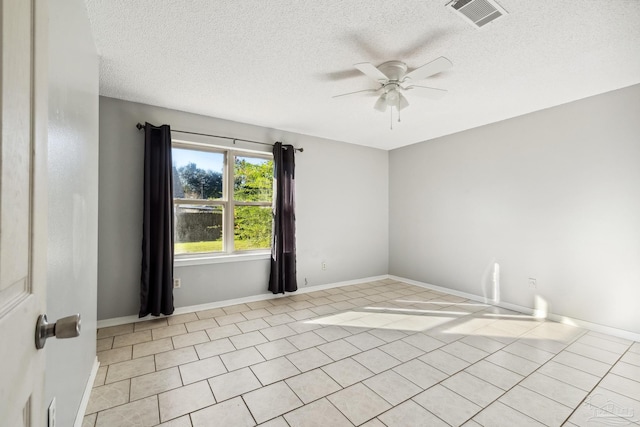 empty room featuring ceiling fan, light tile patterned floors, and a textured ceiling