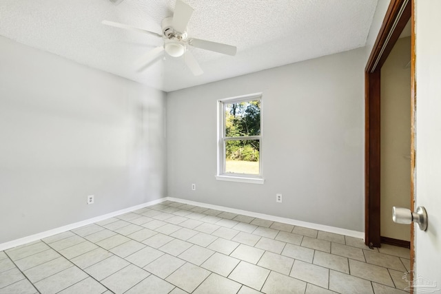 tiled empty room featuring ceiling fan and a textured ceiling