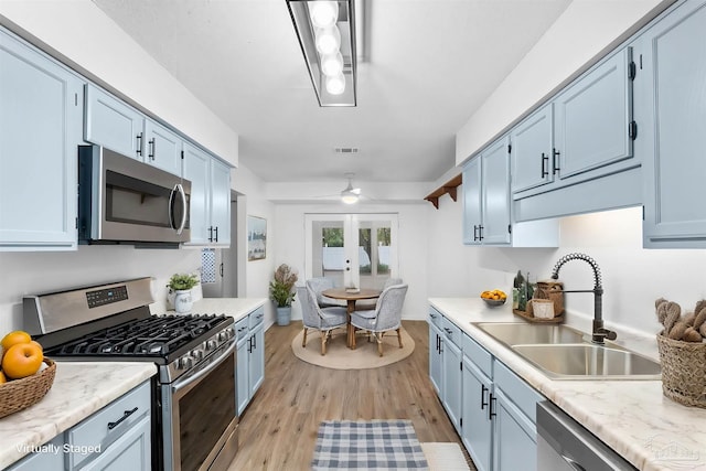 kitchen featuring blue cabinetry, ceiling fan, sink, french doors, and stainless steel appliances